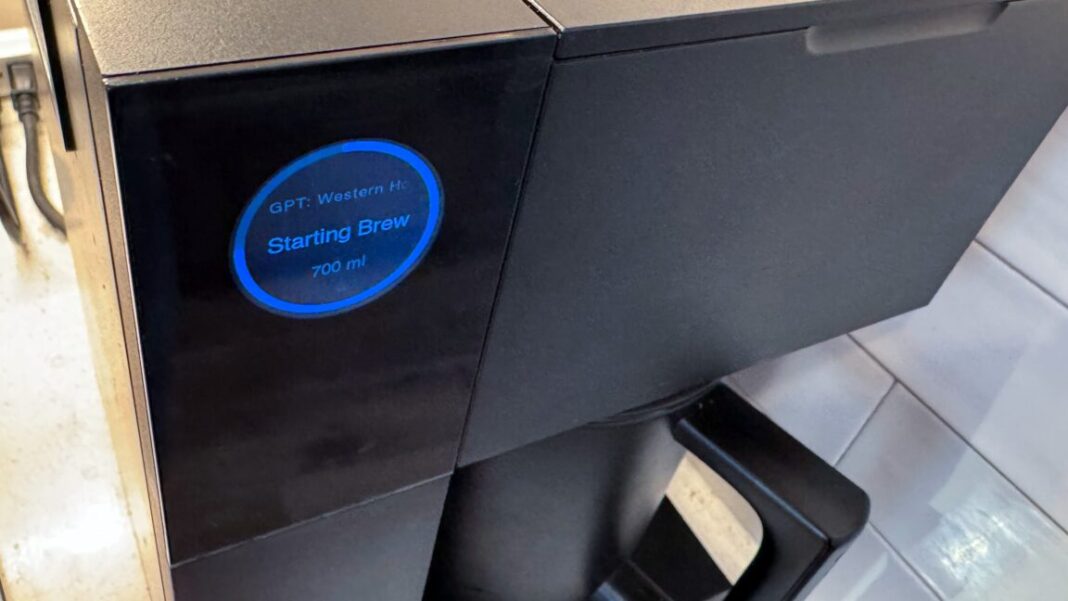 A Fellow Aiden coffee brewer, showing a blue circle on its circular screen, with "Starting brew: GPT: Western House" in text.
